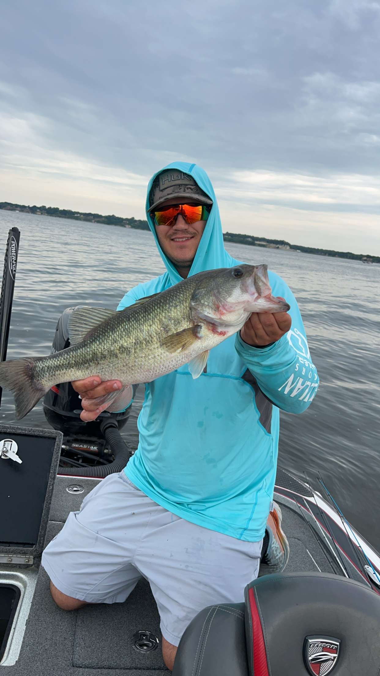 Tanner Bracken holding a largemouth bass on the boat